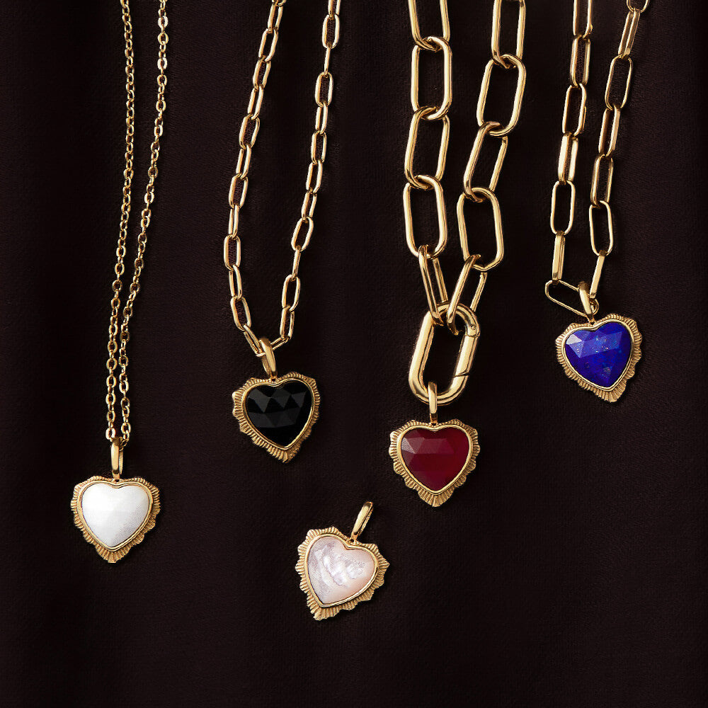 Gold heart pendant necklaces with semi-precious stone in white, black, pink, red and blue stones on layered burgundy fabric